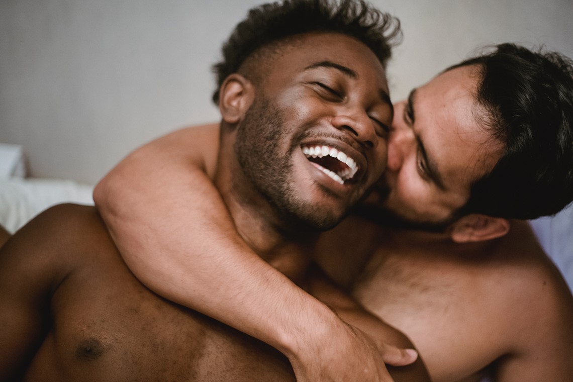 Happy couple laughing, kissing their cheek