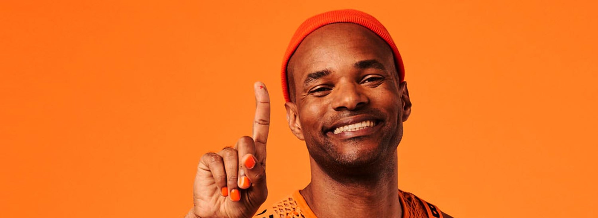 Person in an orange outfit raising their index finger