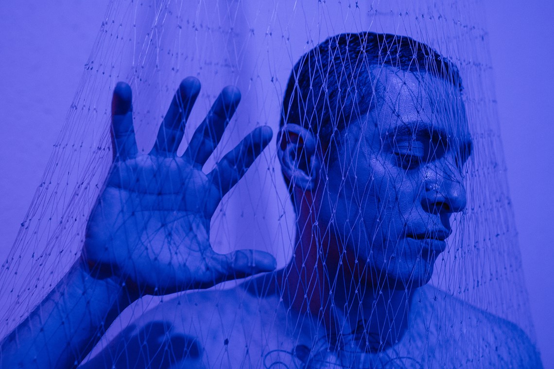 Close up of a person in a net with blue lighting 