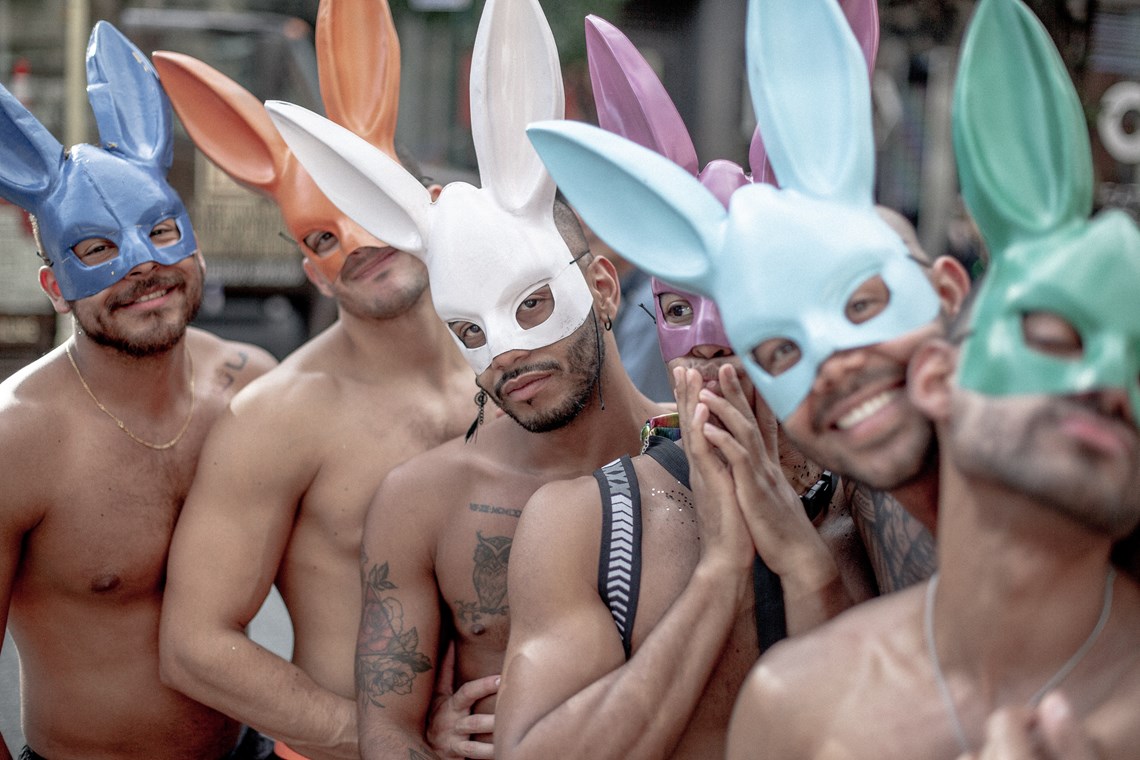 Men posing with different colored bunny masks 