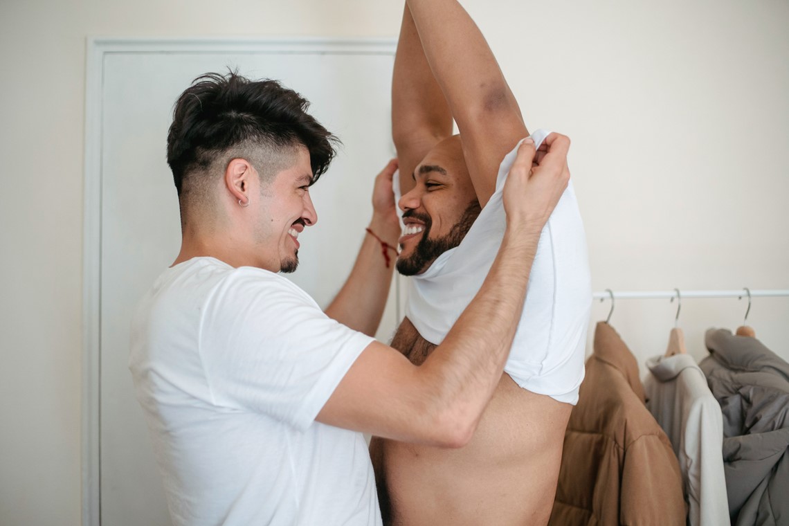 Two men getting undressed, taking their shirts off