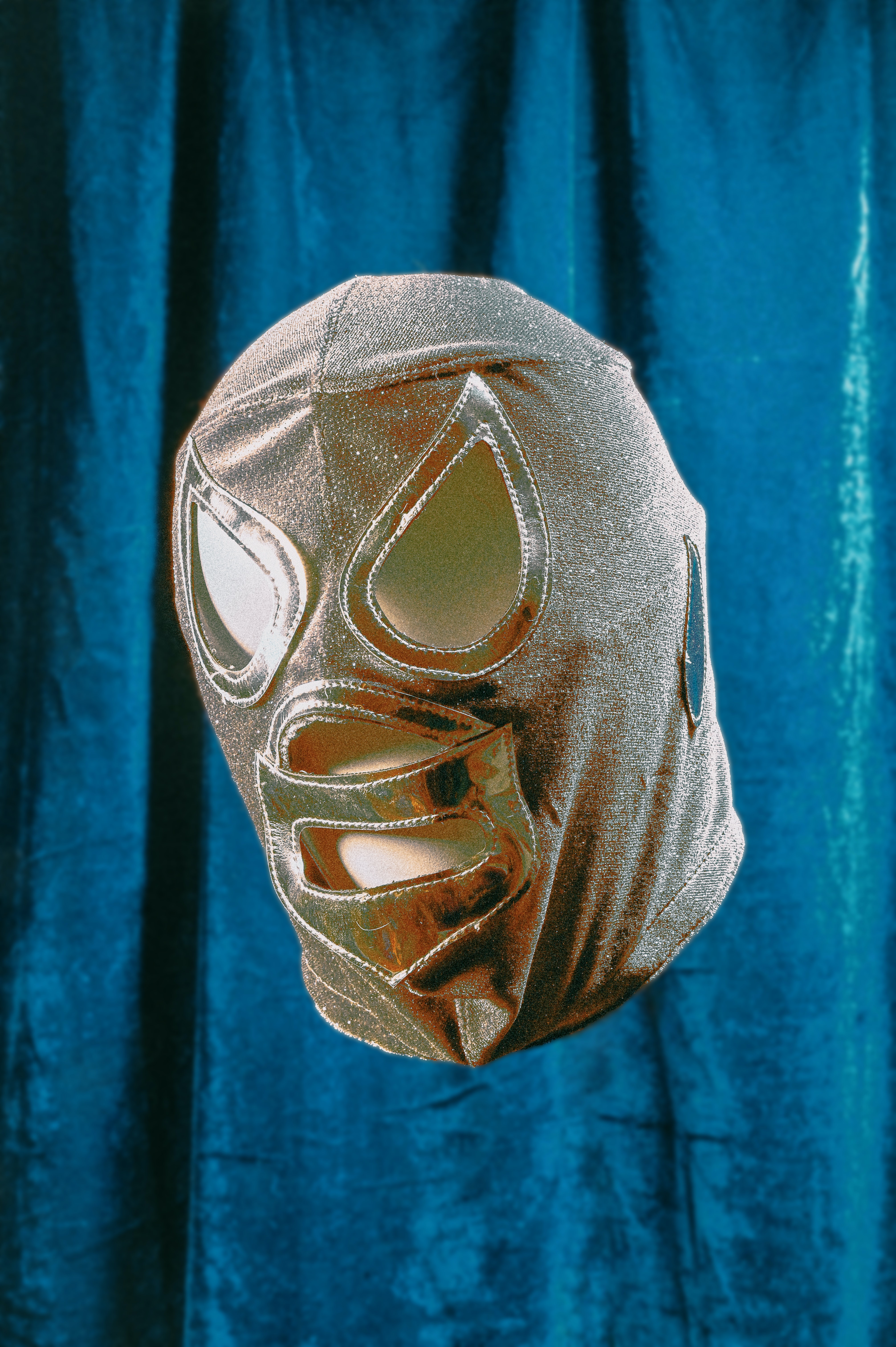 Gold bondage mask in-front of a blue sheet