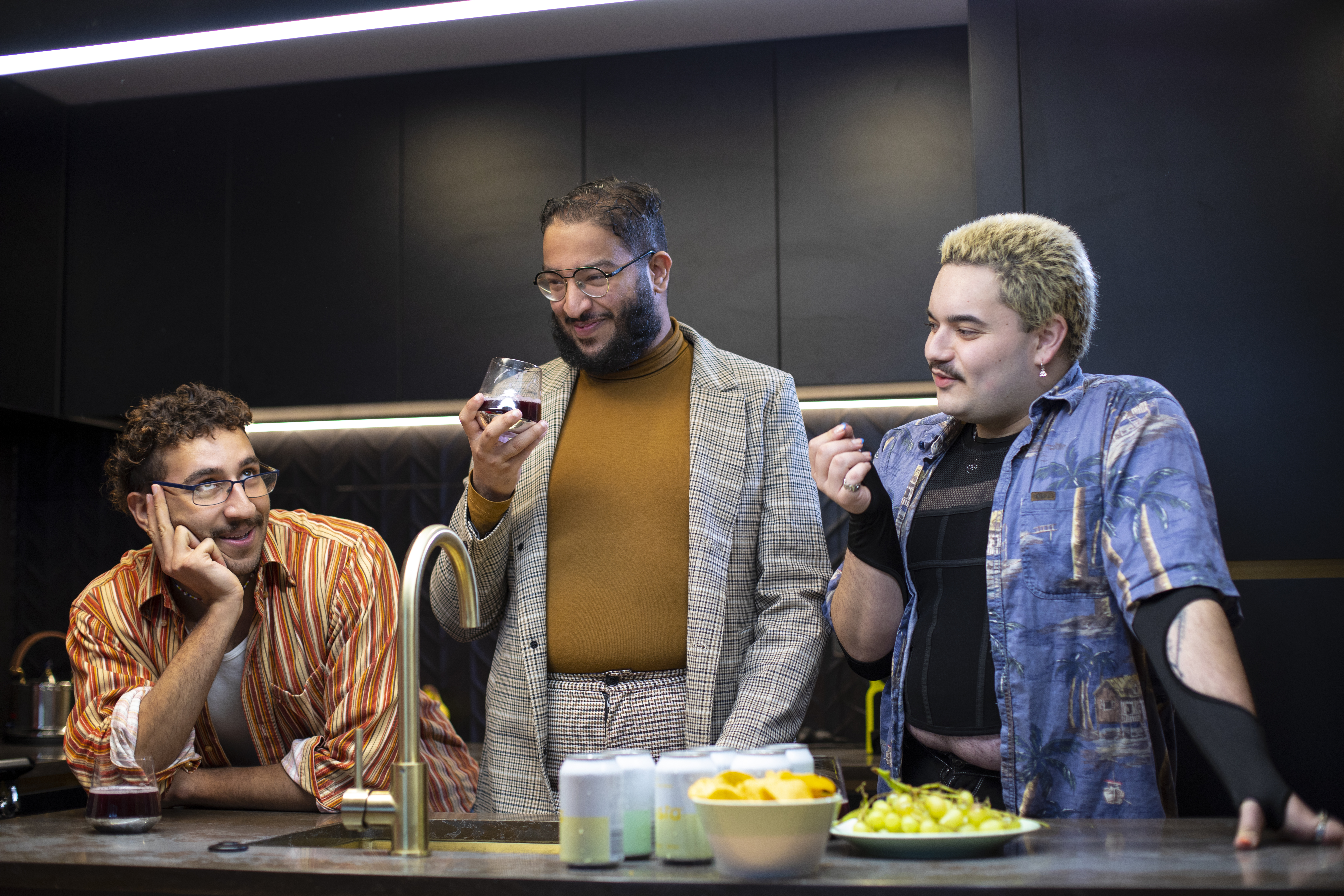 Three people drinking and partying in the kitchen