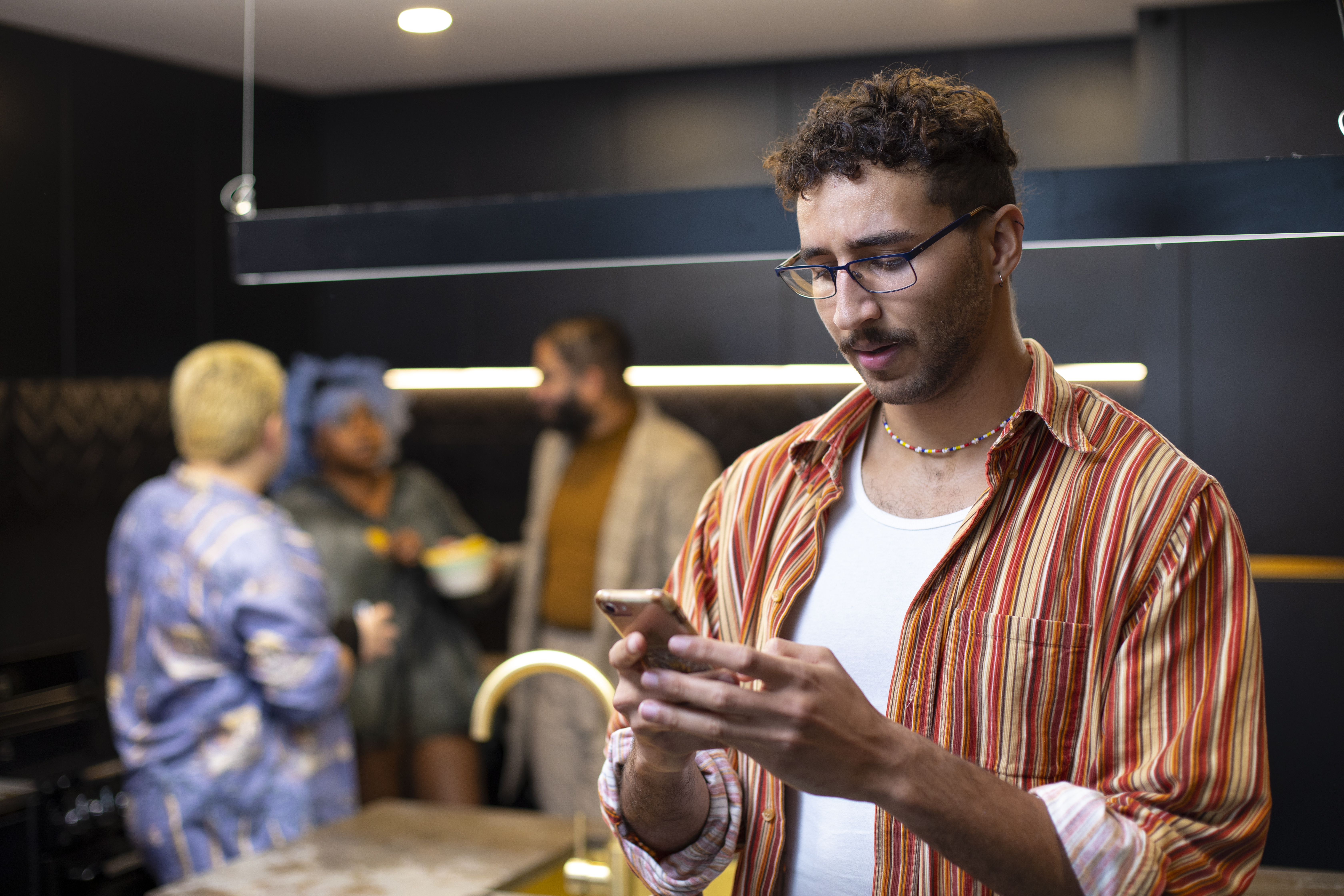 House party, parson looking concerned while using their phone