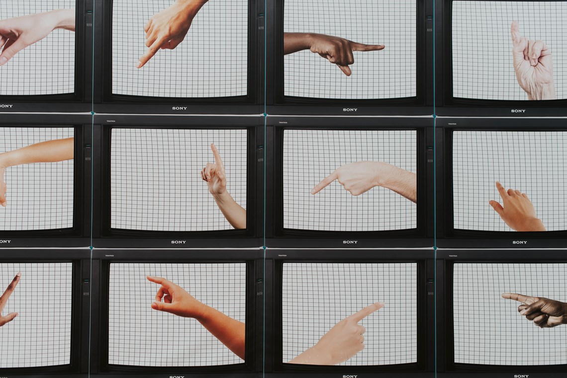 Collection of TV's displaying pointing hands