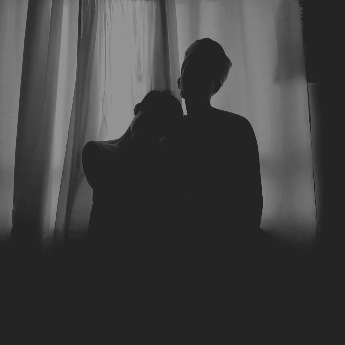 Two people posing in a dark room