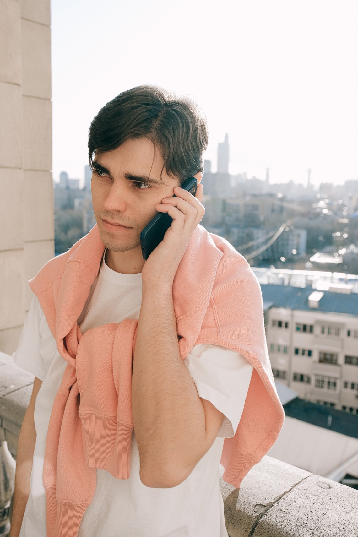 Person on a rooftop, answering a call