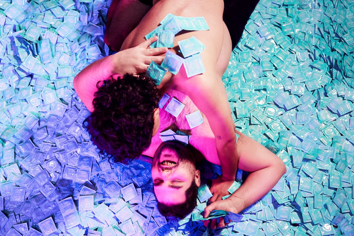 Couple hugging over a pile of condoms